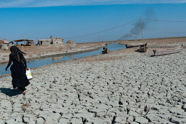 Al-Chibayish, Iraq. November 1st 2018 A Marsh, a woman collecting water in the parched wetlands of the Central Marshes of southern Iraq © John Wreford/Shutterstock